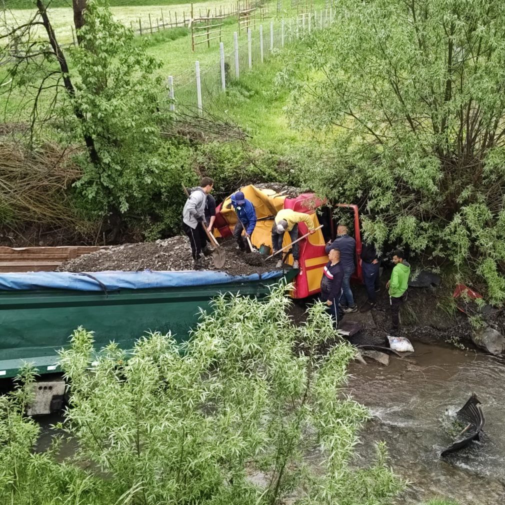 Un camion care transporta piatră s-a răsturnat într-un râu