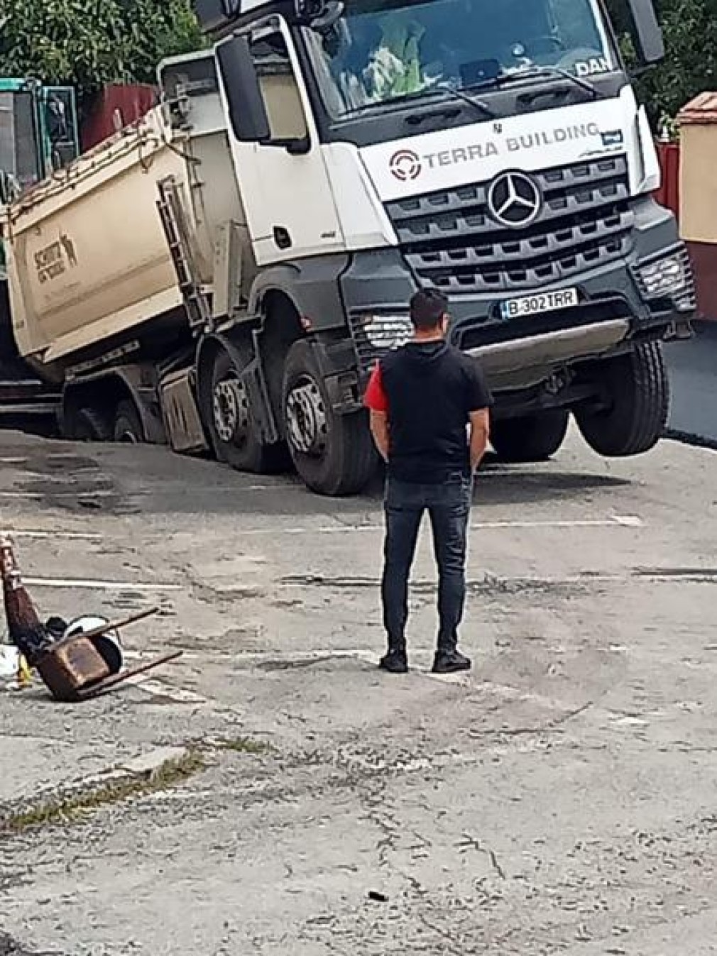 Un camion a rămas cu roțile în aer după ce asfaltul s-a surpat