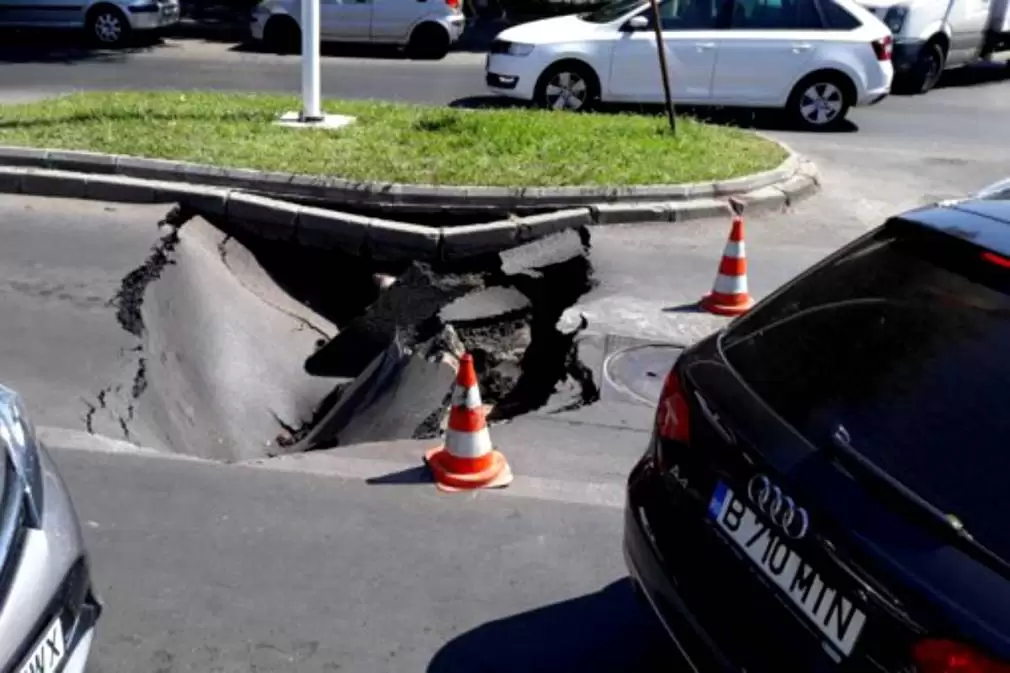 Crater într-o intersecţie din Capitală. O maşină a fost „înghiţită” de asfalt