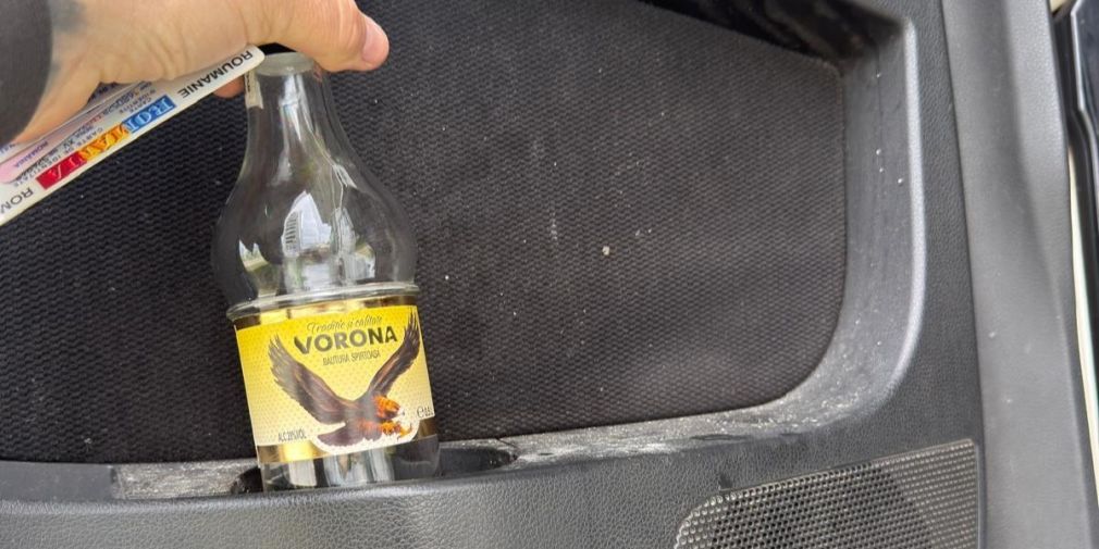 Șofer de camion, depistat în trafic cu sticla de votcă în portieră