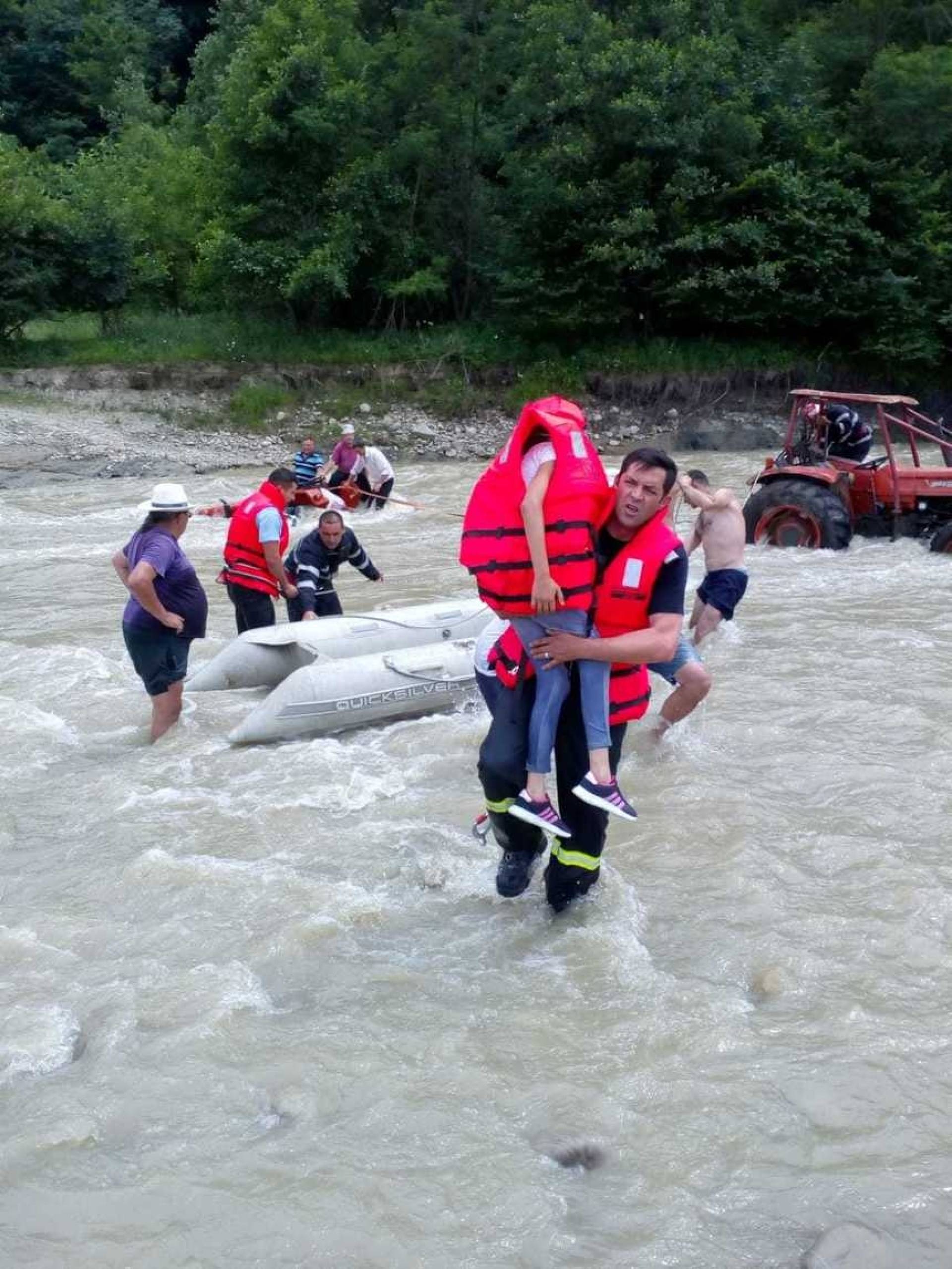 Foto. Două fetițe, salvate în ultima clipă de pe tractorul luat de viitură