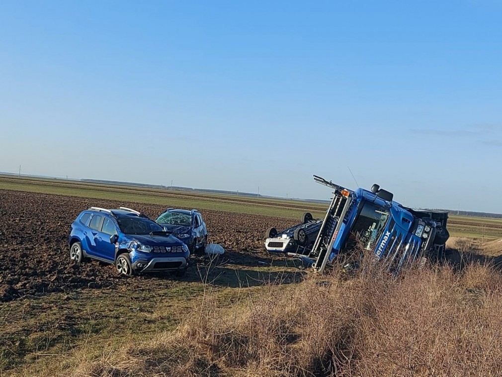 Camion încărcat cu mașini Dacia Duster, răsturnat pe câmp