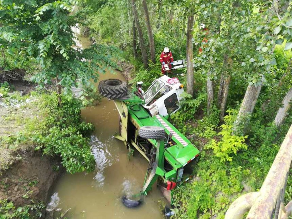 VIDEO: A căzut cu tractorul într-un pârâu şi a rămas prins în cabină
