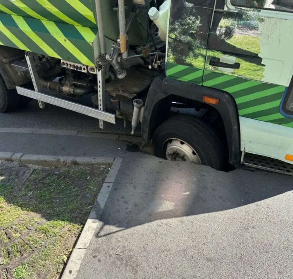 Roata unui camion, „înghițită” de o groapă din carosabil