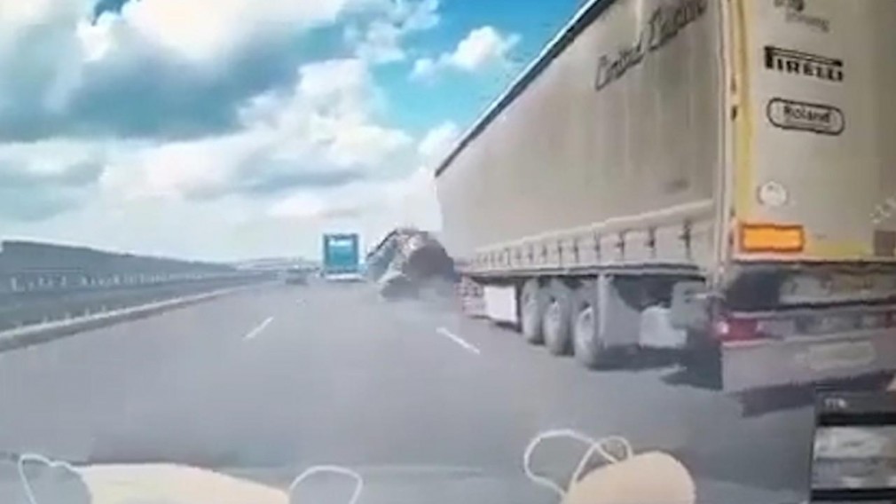 VIDEO. Un BMW condus cu viteză a izbit un camion care s-a răsturnat. Șoferul profesionist a murit