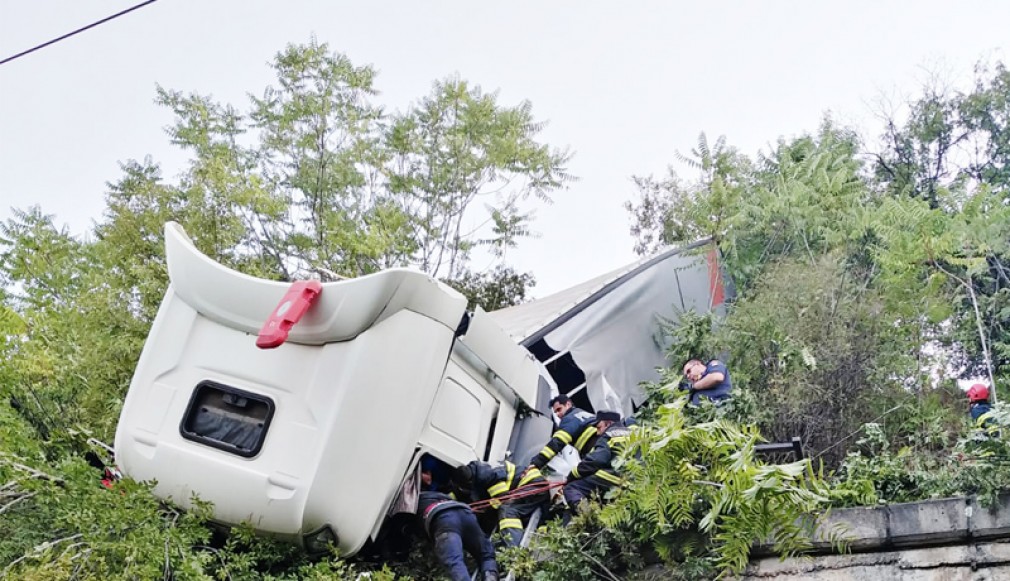 VIDEO. Camion căzut în râpă, șofer blocat în cabină