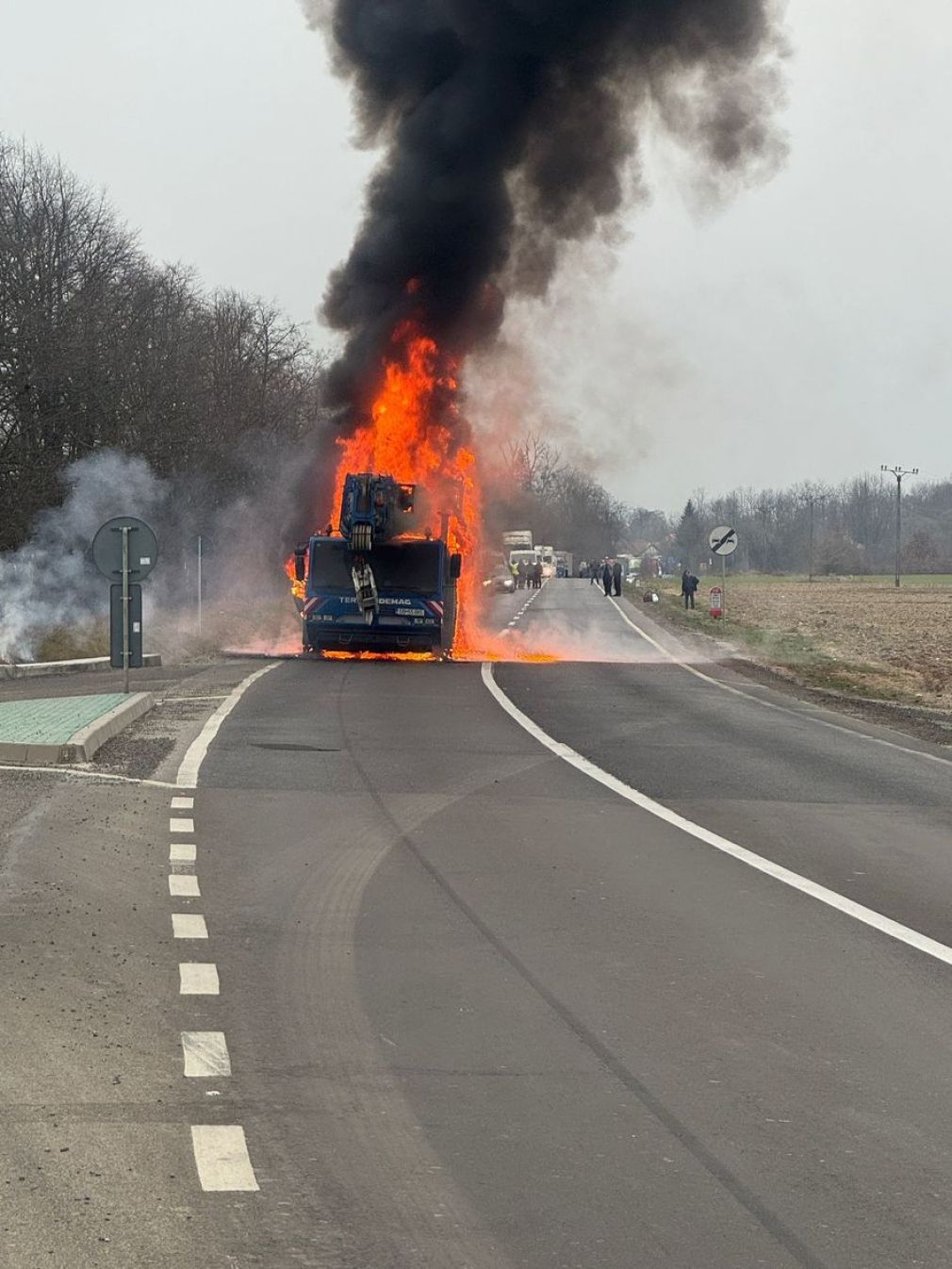 Camion cu macara a luat foc în mers