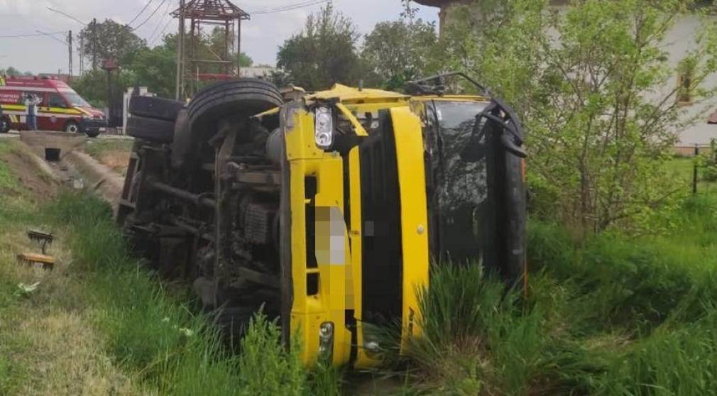 Un camion care transporta un utilaj agricol s-a răsturnat