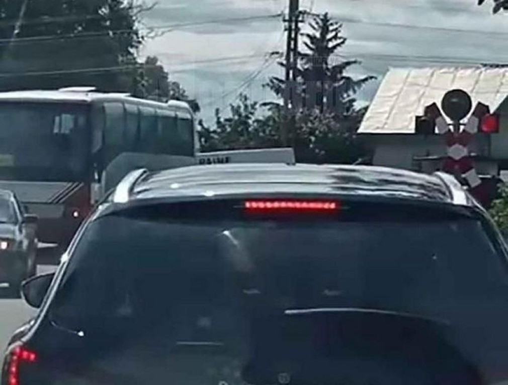 VIDEO Un șofer de autocar a trecut calea ferată prin fața trenului