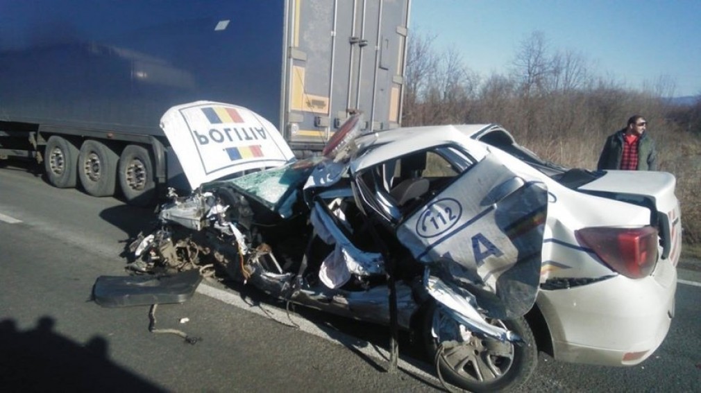 Mașină de poliție făcută praf după un accident cu două camioane