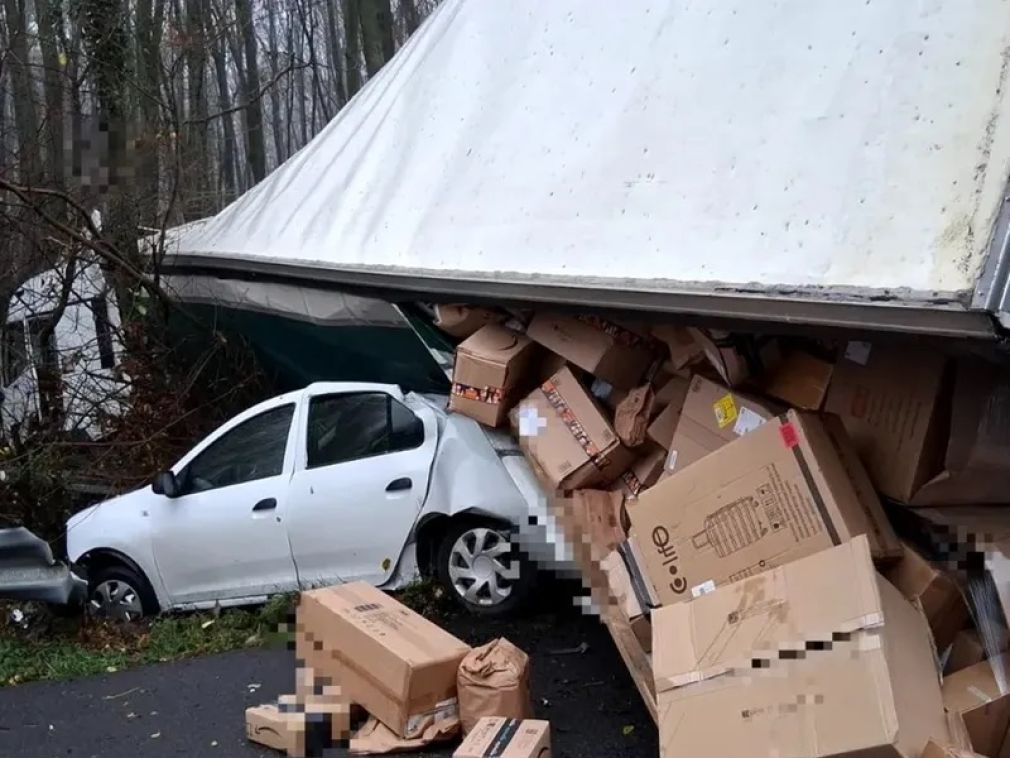 Un camion care duce colete „a căzut” peste un autoturism