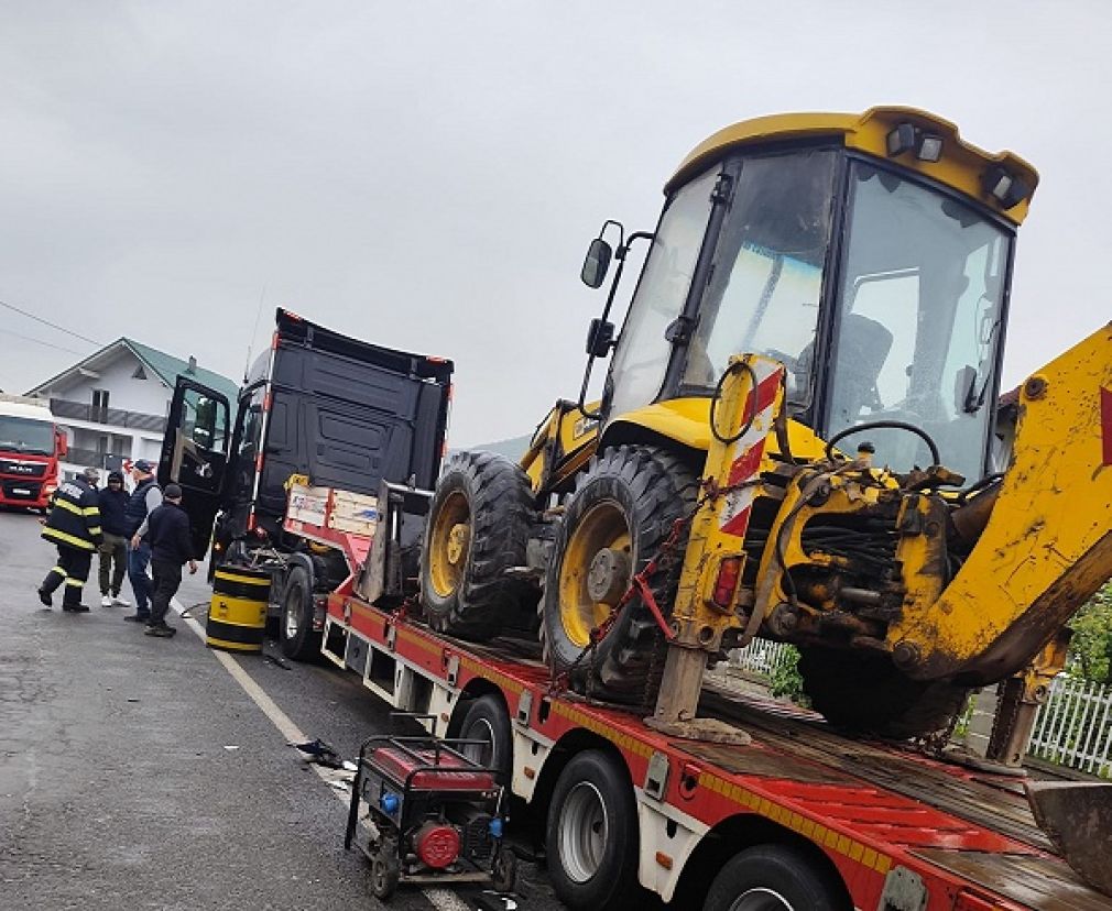 Un camion care ducea un excavator a fost lovit de mașină